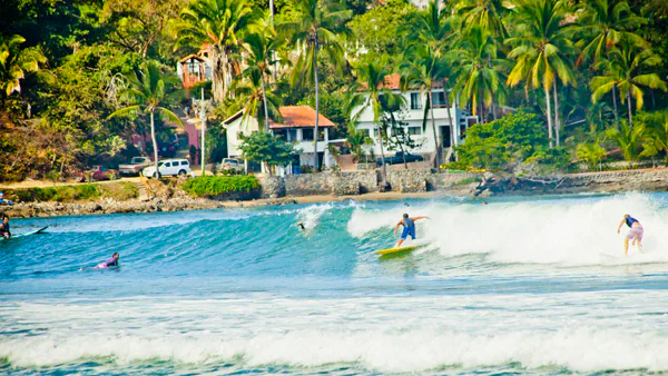 Surfers on a wave off the coast of Sayulita